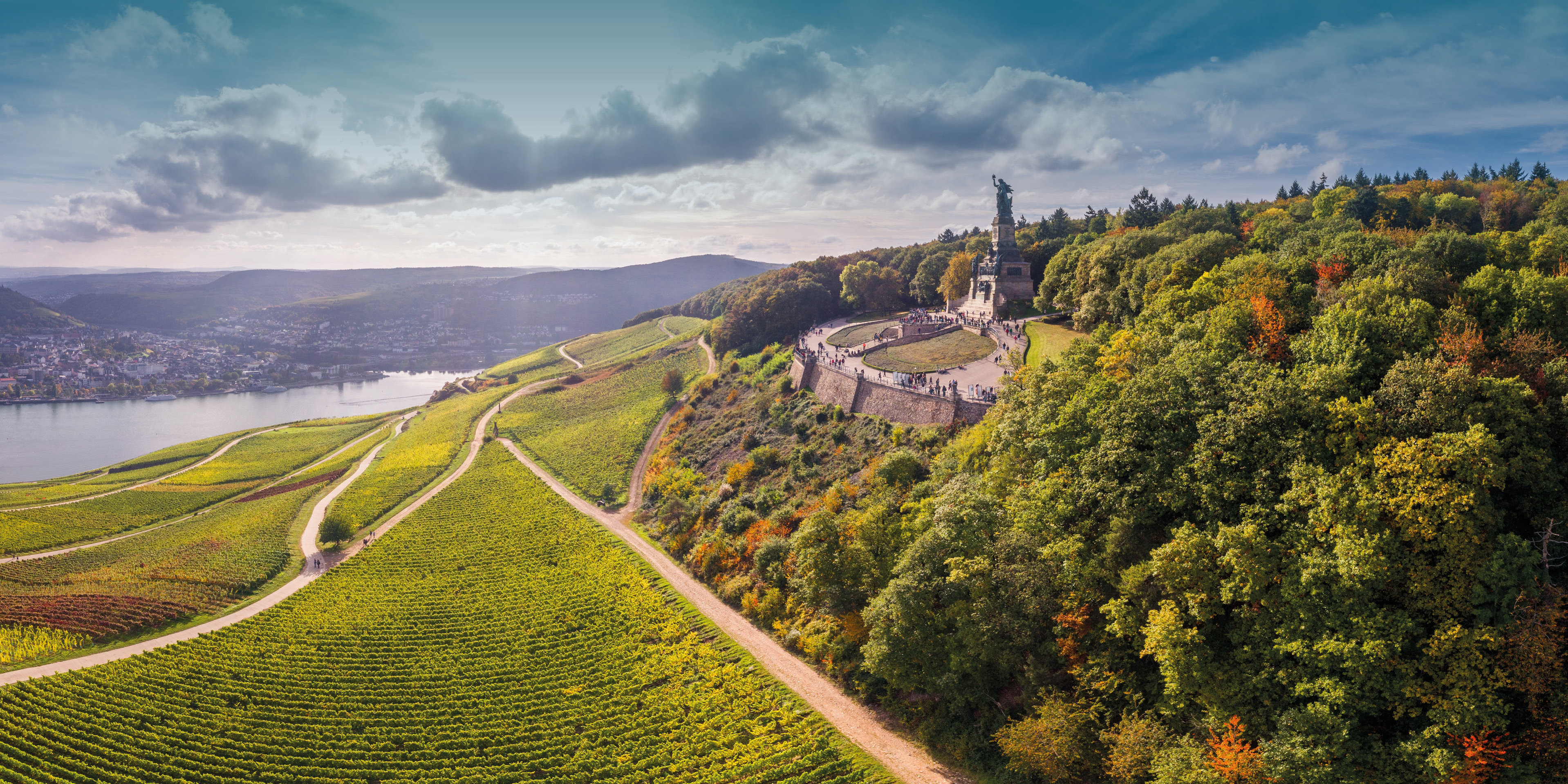 Niederwalddenkmal Rüdesheim  Weitblick auf die Germania und herbstlich gefärbte Weinreben. Der Himmel ist leicht bewölkt.