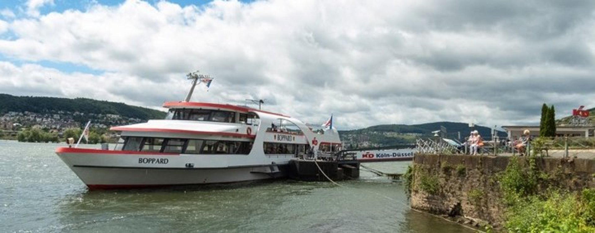 Loreley Tour Das Schiff mit dem Namen Boppard liegt an einem Schiffsanleger mit der Aufschrfit KD Düsseldorfer an Land an.