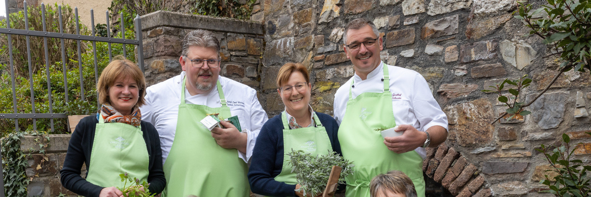 Kräuterwirte Assmannshausen Die fünf Kräuterwirte stehen zusammen und halten verschiedene regionale und einheimische Kräuter in den Händen.