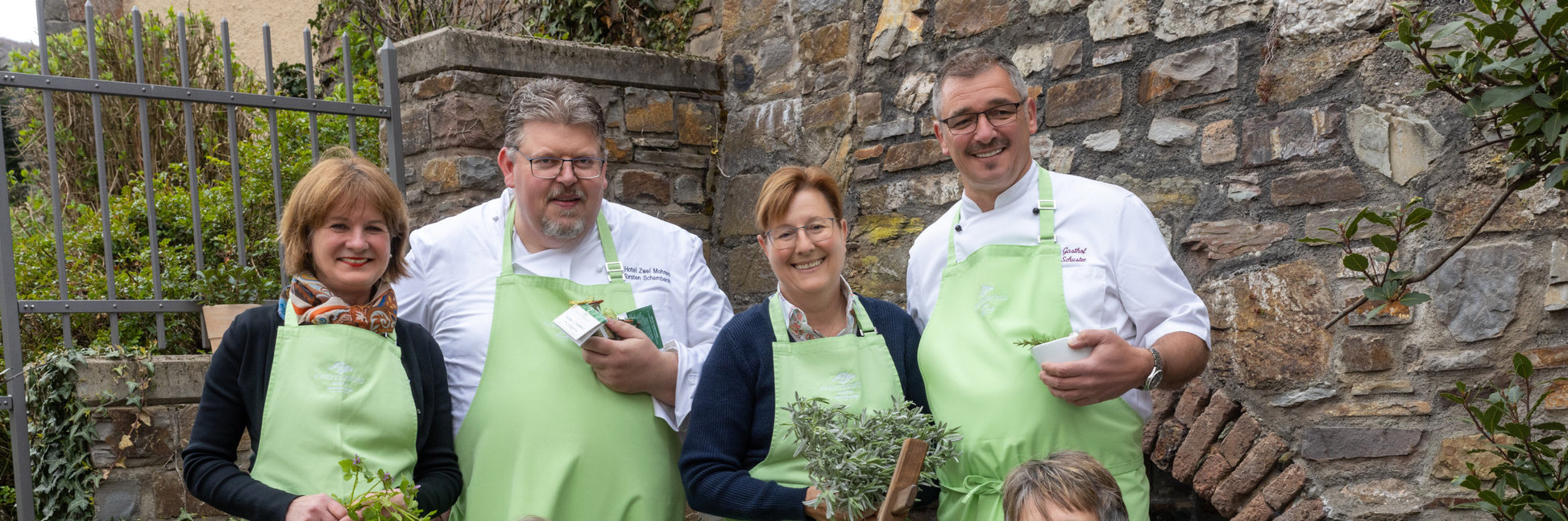 Kräuterwirte Assmannshausen Die fünf Kräuterwirte stehen zusammen und halten verschiedene regionale und einheimische Kräuter in den Händen.